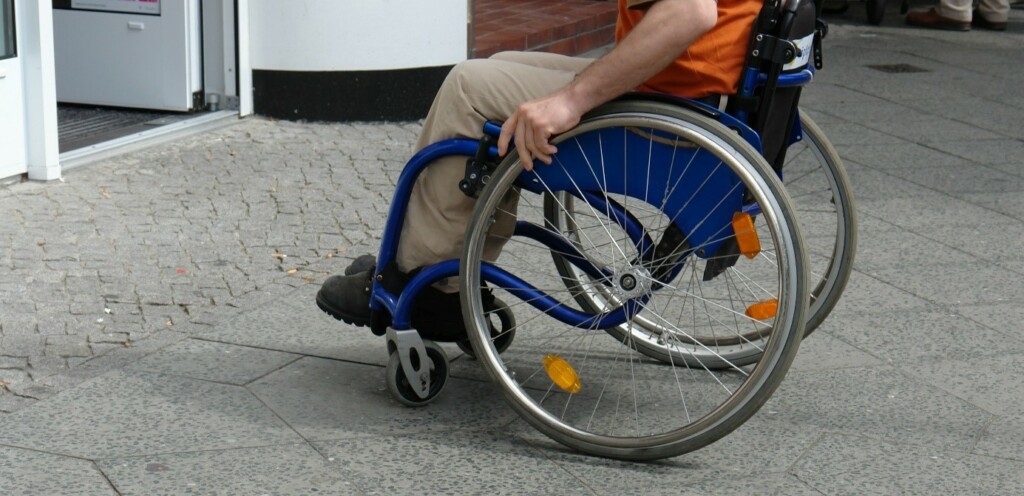 une personne en fauteuil roulant proche d'un seuil de porte d'entrée
