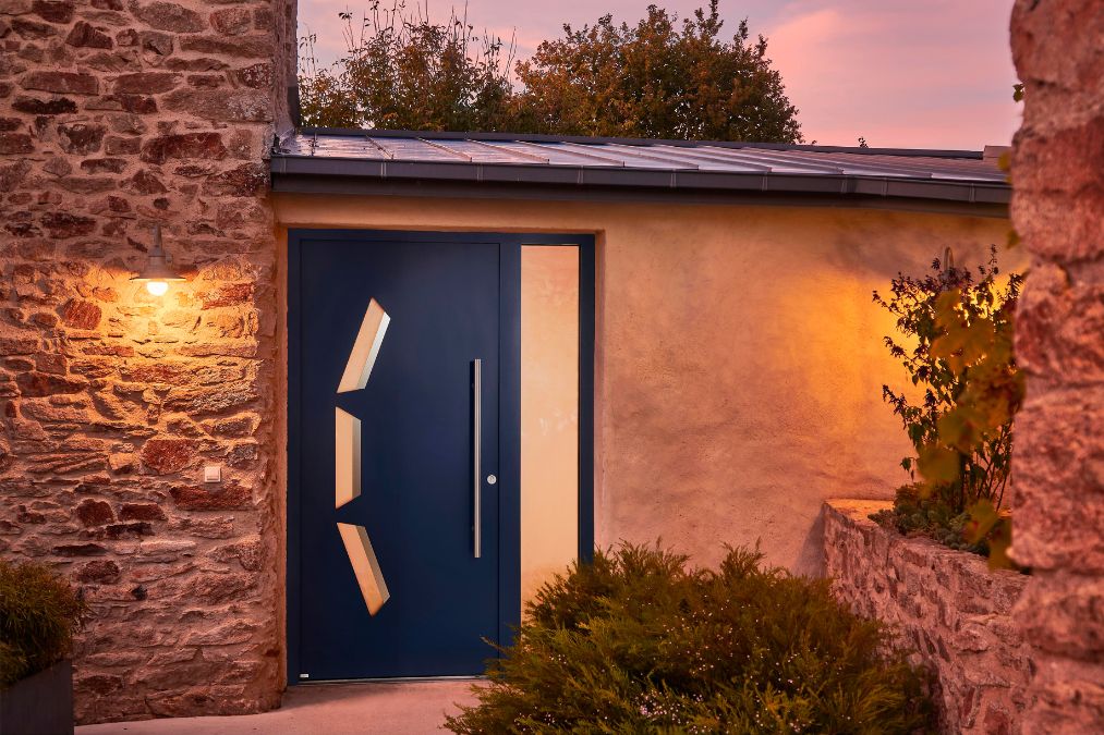 porte d'entrée présentée en grande largeur avec un semi fixe vitré sur une maison en pierre