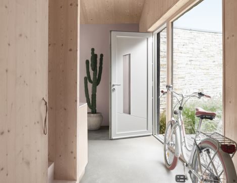 une porte d'entrée vitrée blanche en pvc dans une maison au style minimaliste