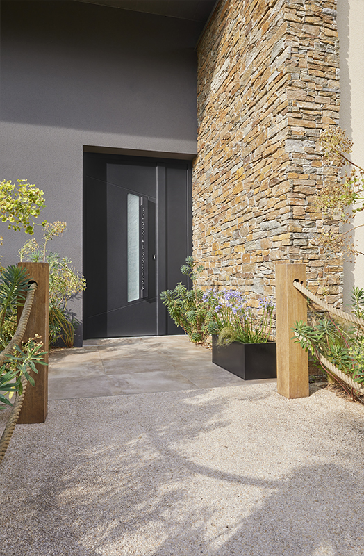 porte d'entrée contemporaine sur une maison avec parement de pierre