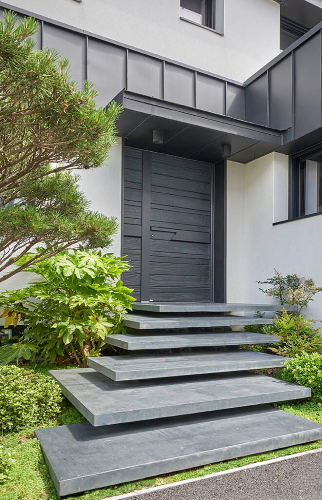 porte d'entrée en bois brûlé modèle nativ 22 fusion de la marque zilten sur une maison contemporaine