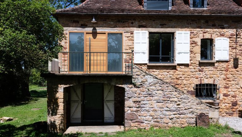 porte d'entrée en bois moderne sur une maison ancienne avec deux fixes vitrés