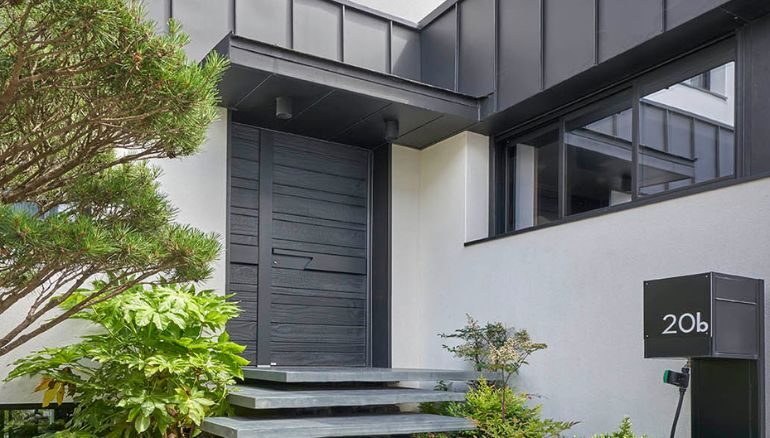 porte d'entrée en bois brulé sur une maison design et contemporaine